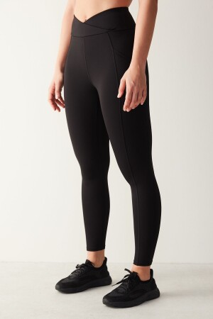 Schwarze knöchellange Leggings mit überkreuzter Taille und detaillierter Tasche - 1